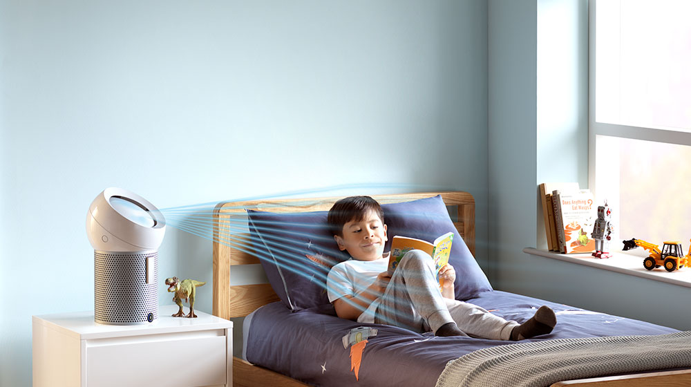 在床上閱讀的男孩，Dyson個人空氣淨化風扇正為他吹送涼風