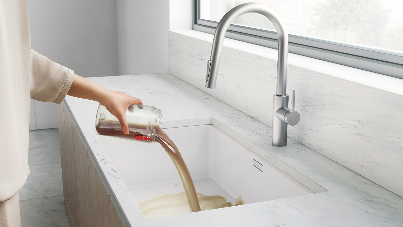 使用者正在將污水箱內的污水倒進水槽