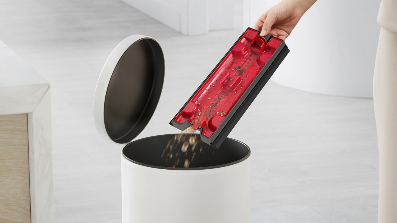 使用者正在將碎屑清空至垃圾桶內