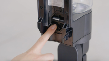 使用者指著已取下止回閥和蓋子的地方