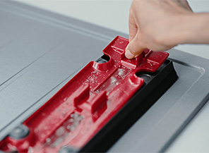 使用者正在將紅色內部區塊從碎屑盤的外殼上取出