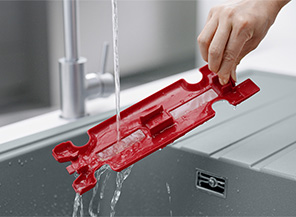 使用者在流水下沖洗紅色內部區塊