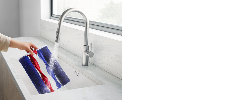 使用者在水龍頭下沖洗超細纖維滾筒和輔助滾筒刷條