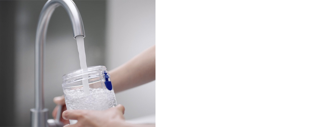 使用者在水龍頭下清洗水箱