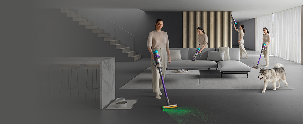 Woman cleaning all around room, up high, on sofa, carpet and hard floor.