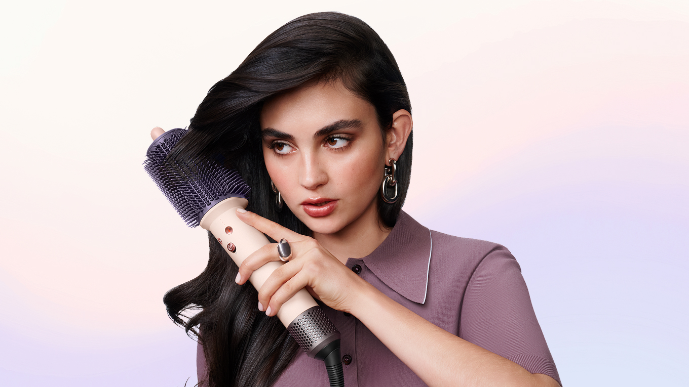 模特兒使用 Dyson Airsmooth 造型梳梳理頭髮。