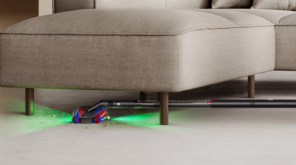 Person using Dyson Pencilvac cleaner under sofa