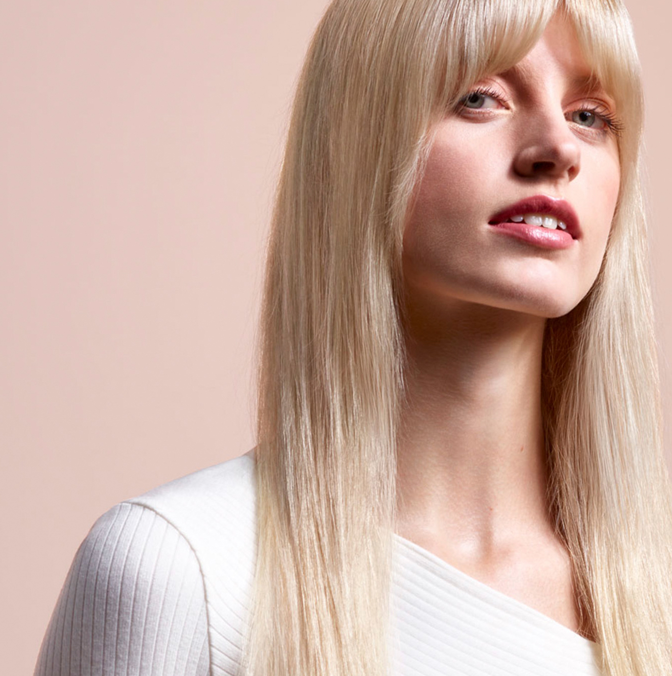 A model with long, blonde hair wearing a straight style.