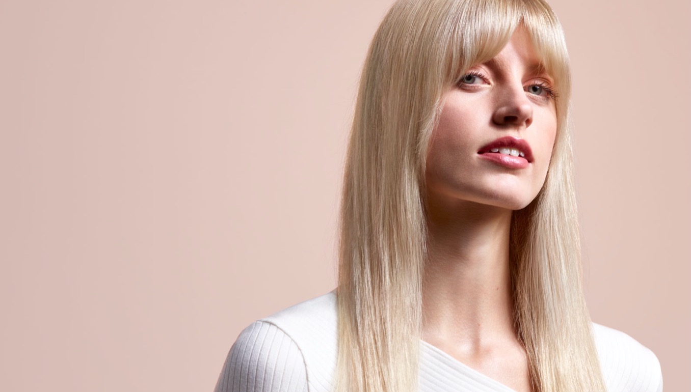 A model with long, blonde hair wearing a straight style.