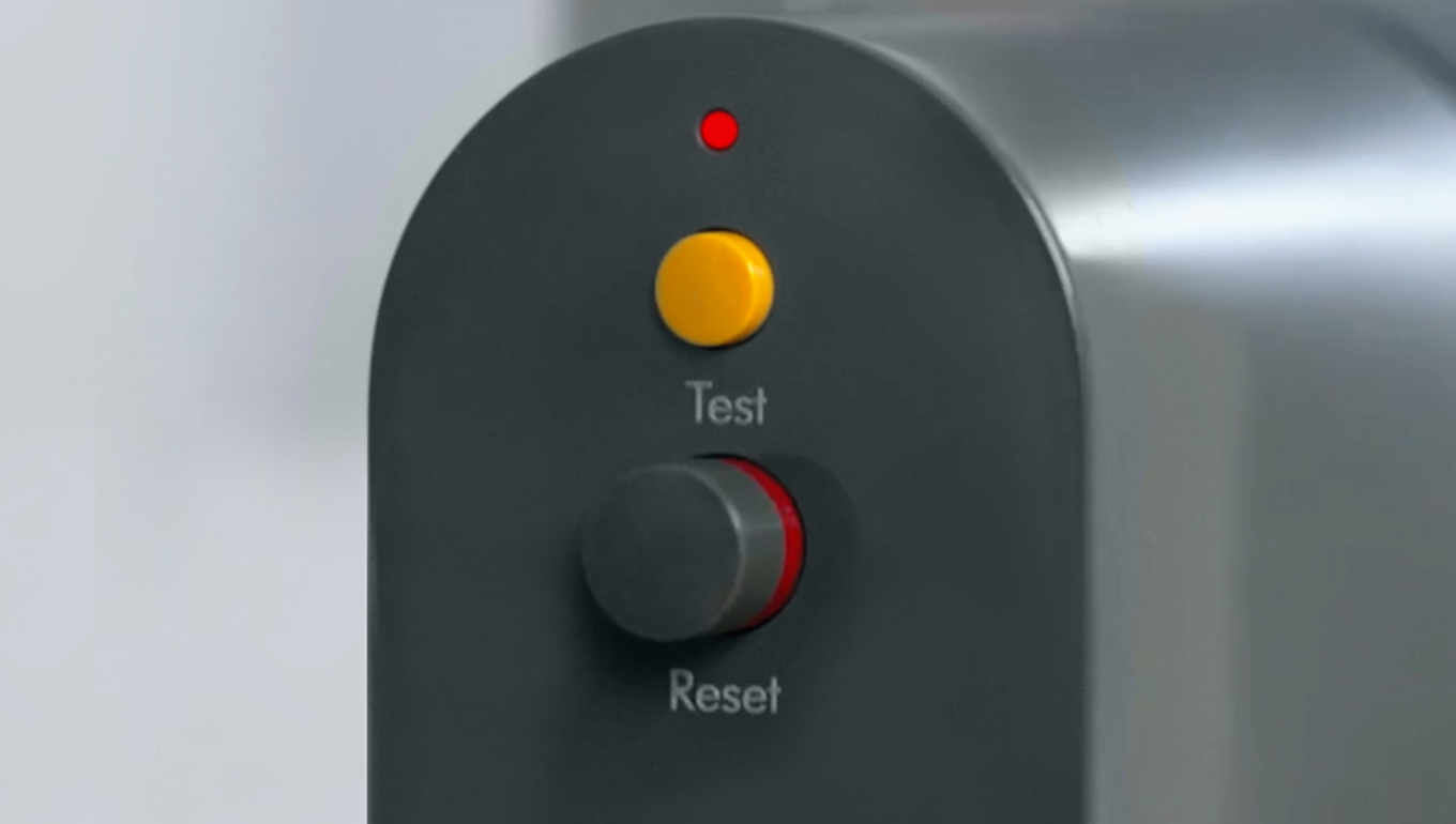 A close-up of both the test button and reset button on the PRCD plug, with the LED light lit above PRCD colours and button positioning might vary.