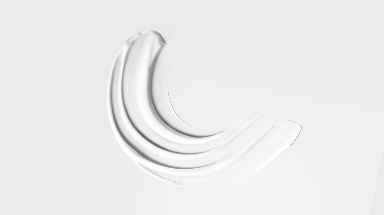 A swipe of pre-style cream on white background, showing texture.